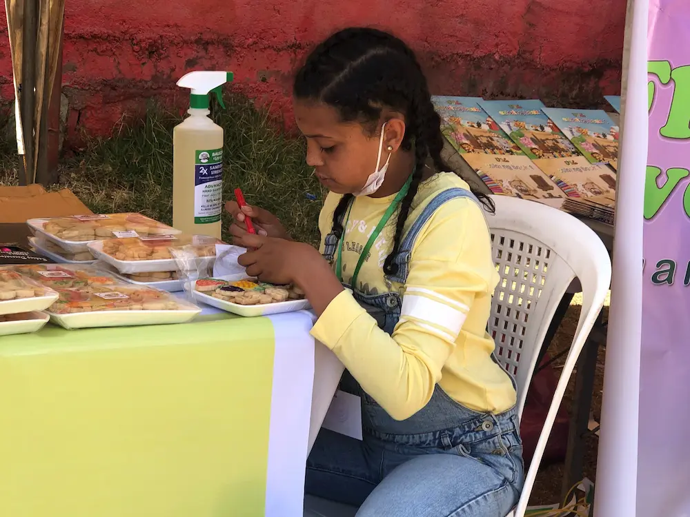 A young girl coloring cookies with edible marker